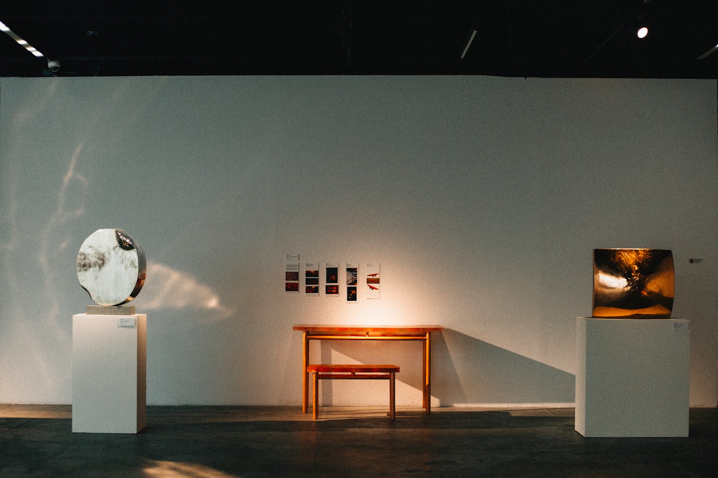 Deux sculptures abstraites dans une galerie d'art minimaliste.
